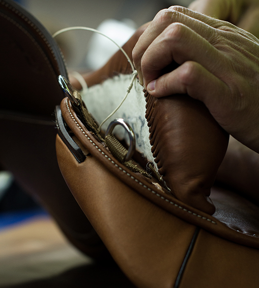 Fifth step in making a custom-made leather horse saddle for Antares riding: assembling the various parts of the horse saddle by hand